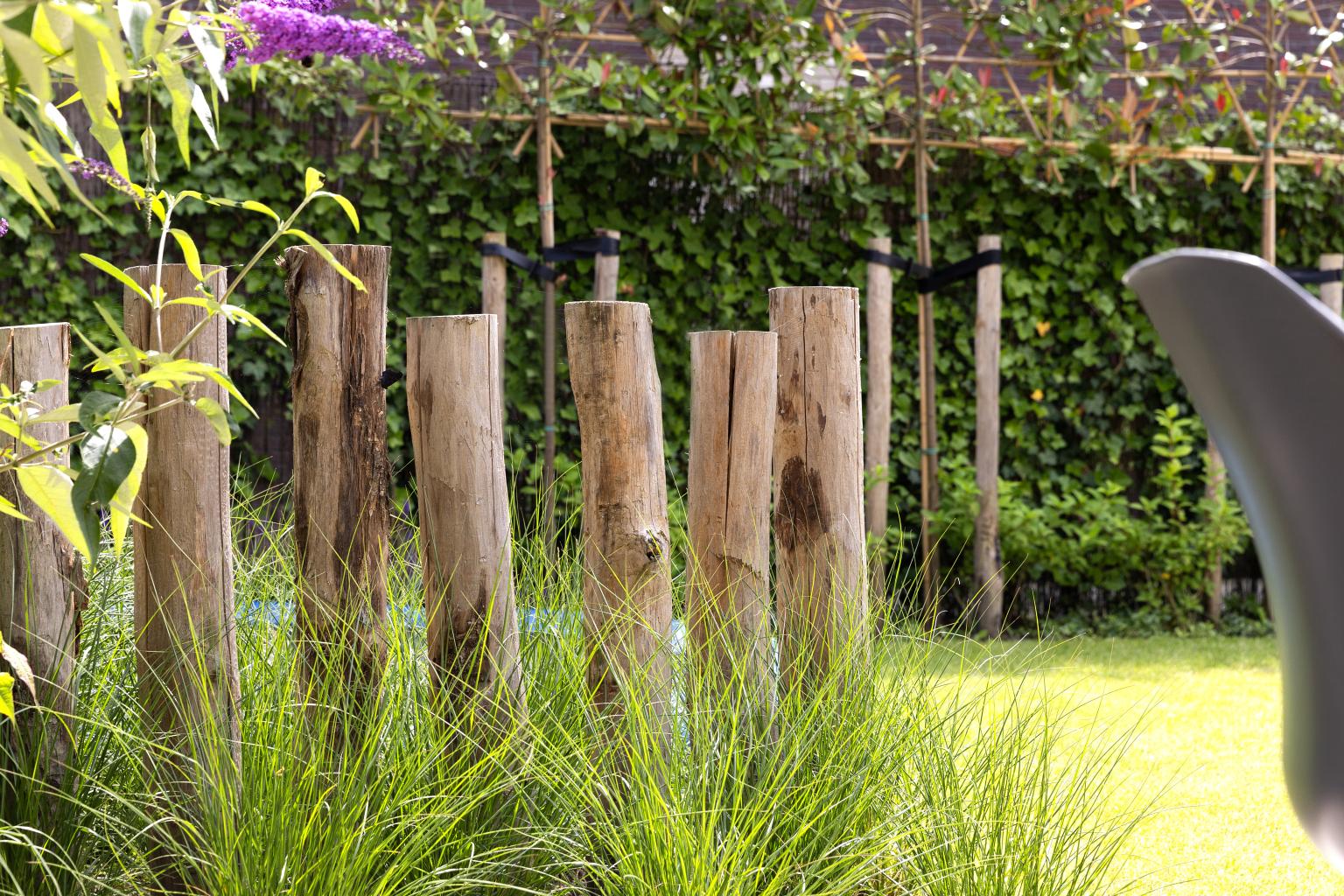 Kastanjepalen als afscheiding met siergras